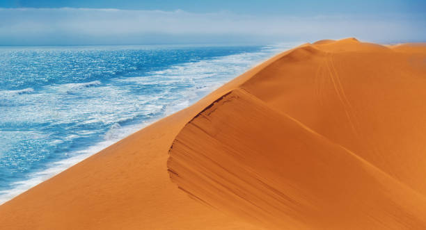 Sand Dunes and Ocean near Walvis Bay, Namibia. Coast of the atlantica ocean at the Namib-Naukluft national park, Namibia, south of Africa.