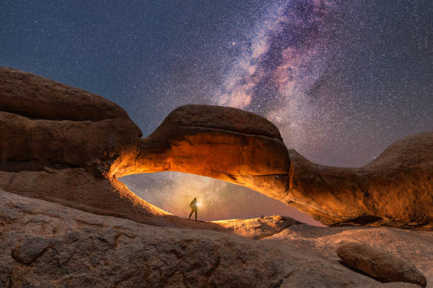 Spitzkoppe Nature Reserve in Namibia, gorgeous stone arches painted with iron oxide in red-orange at night and the Milky Way.